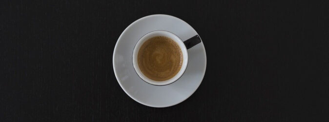 Bild eines Espressos auf einem schwarzem Tisch.