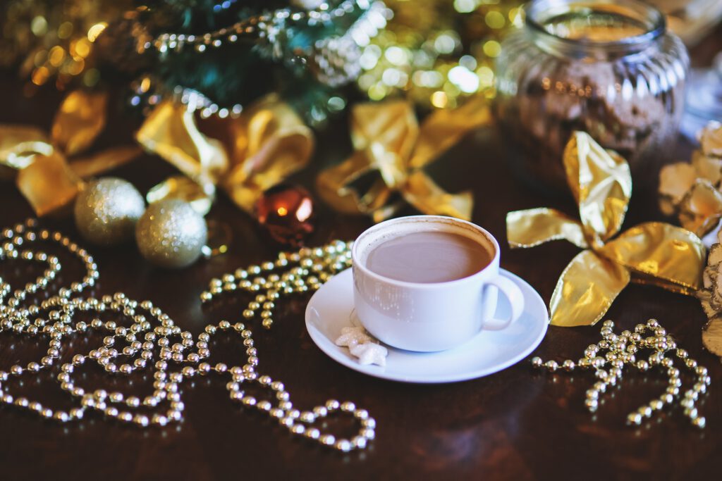 Eine Tasse Kaffee auf einem Tisch umgeben von Weihnachtsdekoration.