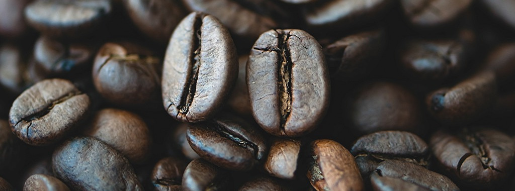 Nahaufnahme von dunkel gerösteten Kaffeebohnen.