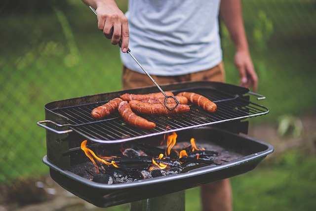 Mann steht am Grill